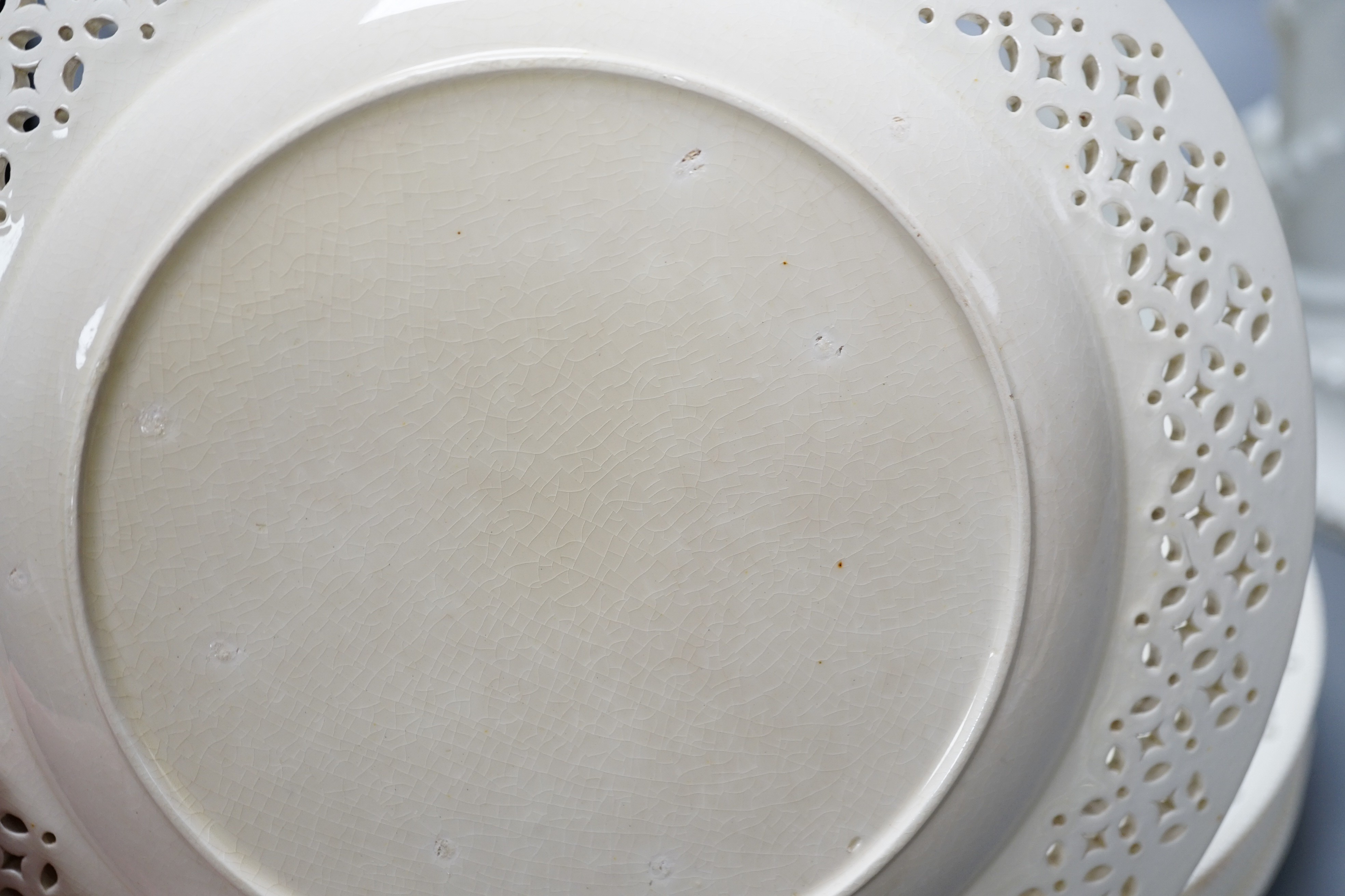 A set of seven early 19th century creamware plates, four later creamware candlesticks and an ivory ground jug. Tallest piece 33cm